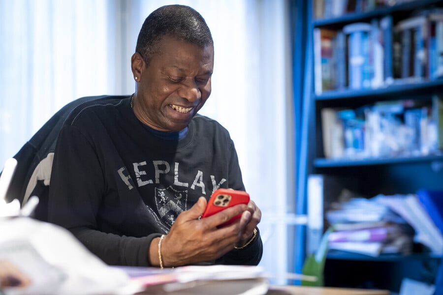 Someone smiling while looking at their smartphone