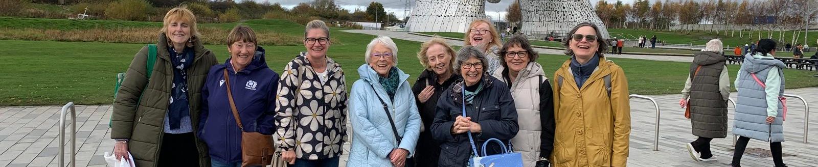 Group of nine women on an outing together at the Kelpies horsehead statues in Falkirk, Scotland