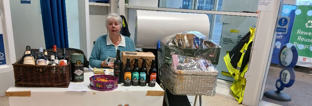 Pictures showing Susan Brown, lipreading tutor, with the raffle prizes at Blairgowrie Tesco